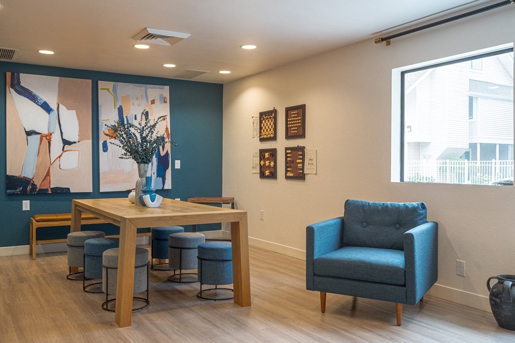 a room with a table and chairs and a large painting on the wall