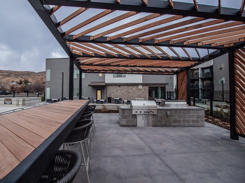 a large patio with a grill and a wooden table