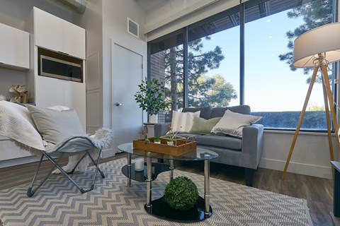 a living room with a large window and a couch and a table