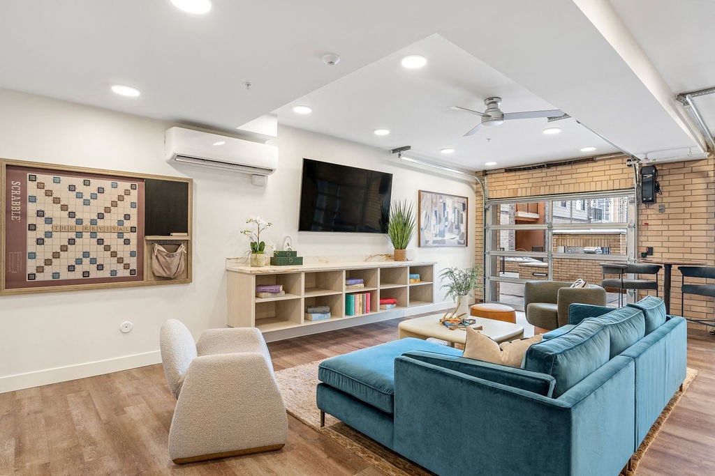 a living room with a blue couch and a television at The Revival, Salt Lake City, 84101