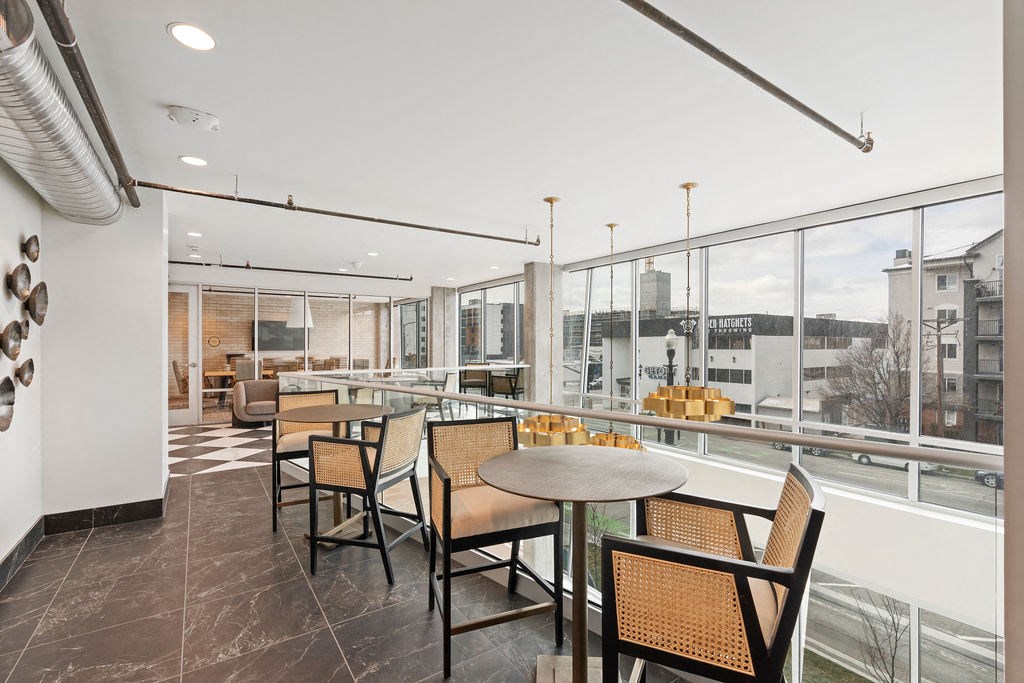 a dining area with tables and chairs and large windows at The Revival, Salt Lake City, UT 84101
