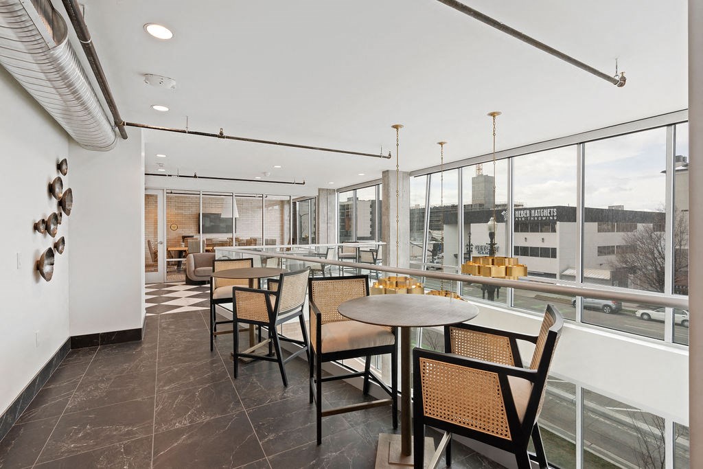 a dining area with tables and chairs and large windows at The Revival, Salt Lake City, 84101