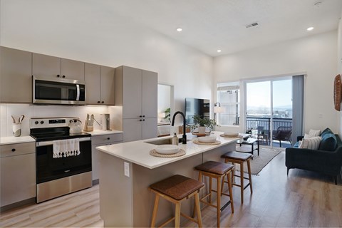 A modern kitchen with a stove top oven and microwave above the island.