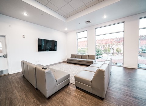 a living room with couches and a tv on the wall