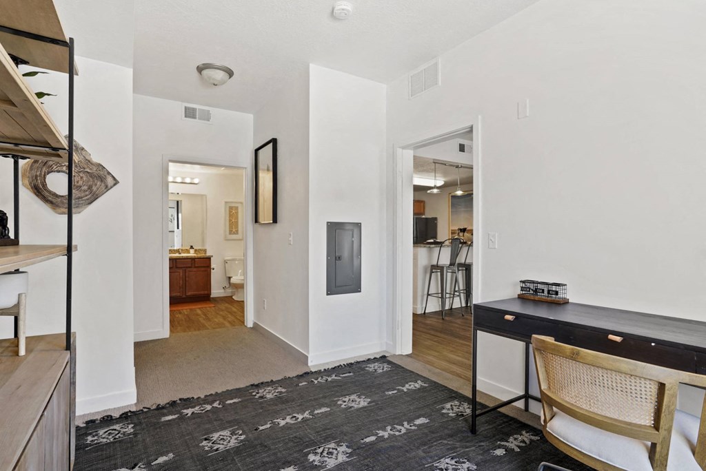 a living room with a desk and a doorway to a kitchen at The View on 20th, Ogden