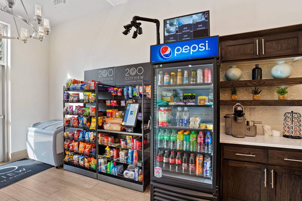 a cooler in a store with a refrigerator and a counter with drinks at 200 City View, Provo, Utah