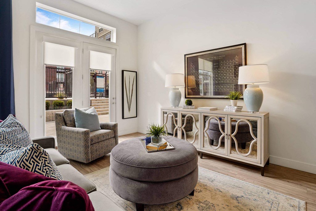 a living room with a couch and a chair and a door to a balcony