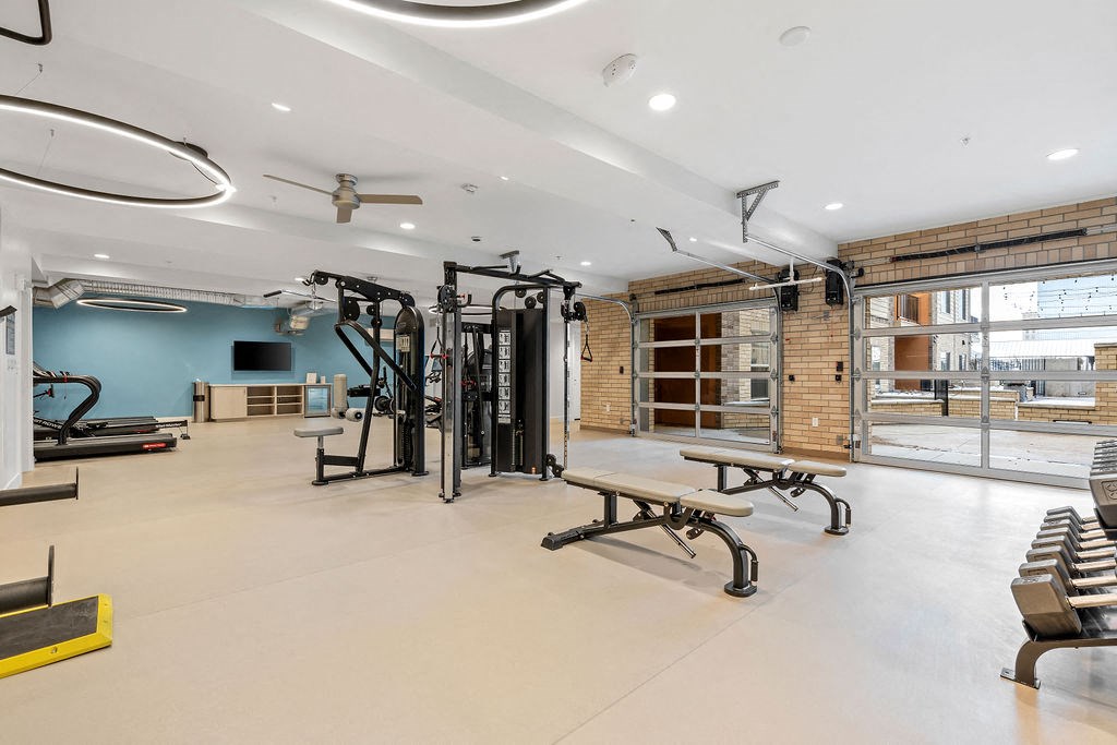 a gym with weights machines and benches and a large window at The Revival, Salt Lake City, UT