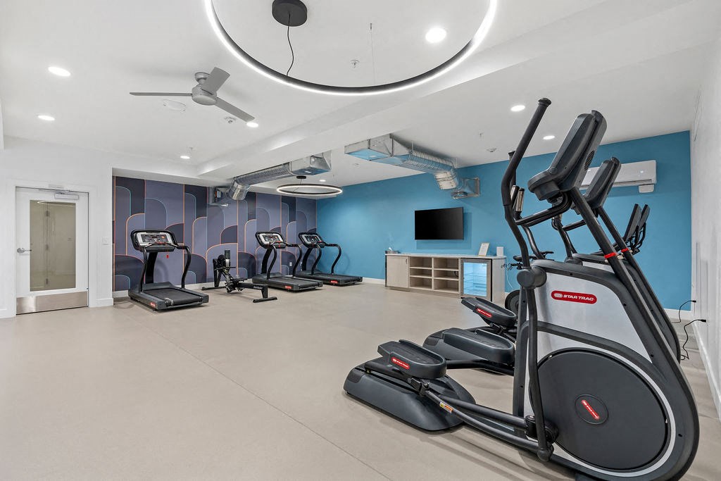 a gym with treadmills and a tv in the ceiling at The Revival, Salt Lake City