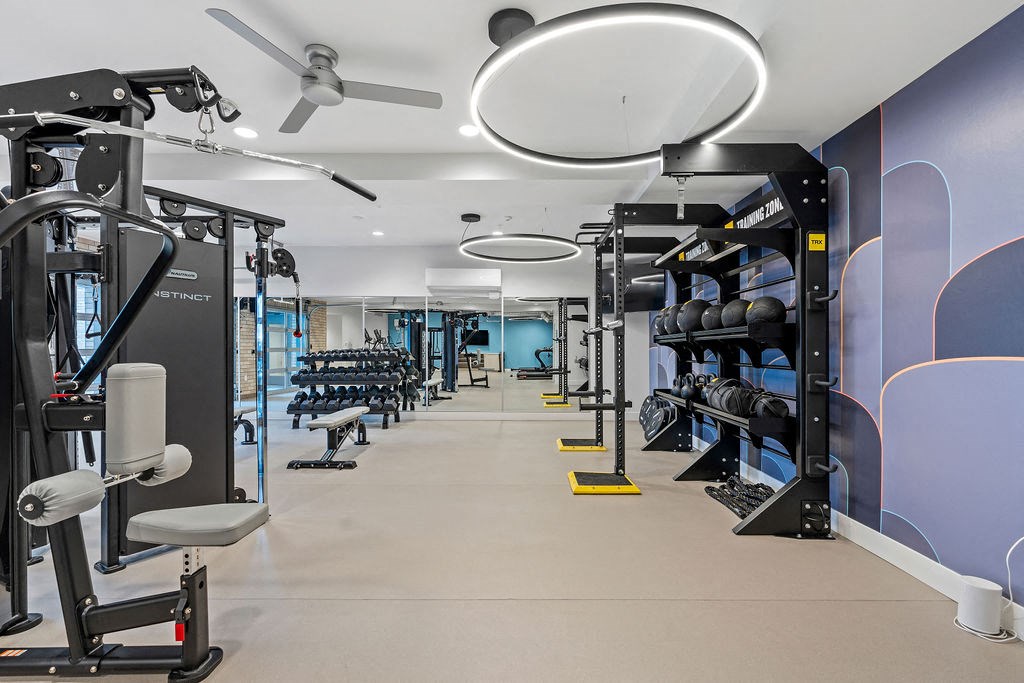 a gym with weights and cardio equipment and a ceiling fan at The Revival, Salt Lake City Utah