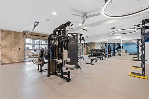 a gym with weights and cardio equipment in a building with brick walls at The Revival, Salt Lake City, 84101