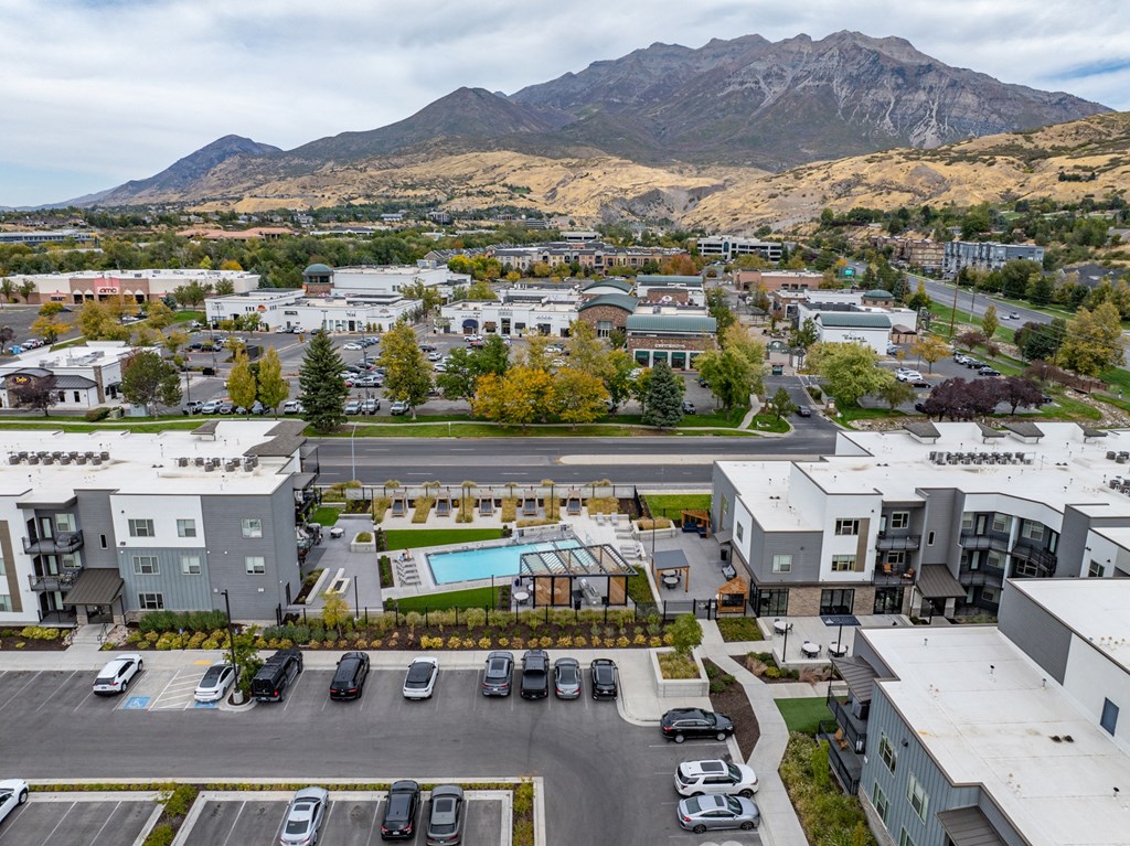an aerial view of an apartment complex with a pool and parking lot at The Flats at Riverwoods, Provo, Utah