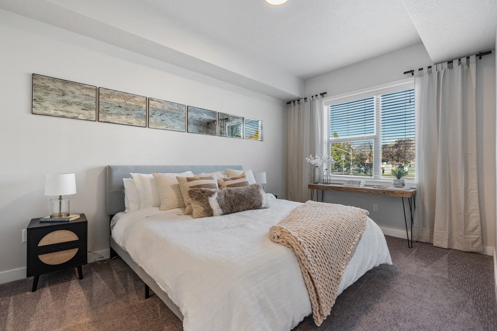 a bedroom with a large bed and a window at The Flats at Riverwoods, Provo, UT, 84604