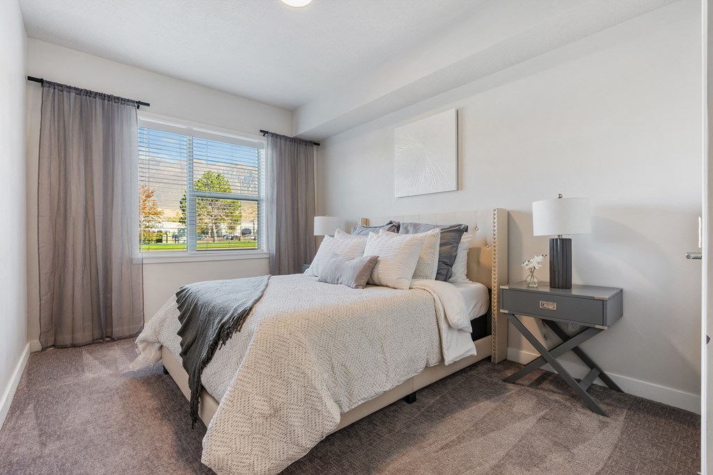 a bedroom with a bed and a window at The Flats at Riverwoods, Provo, UT, 84604