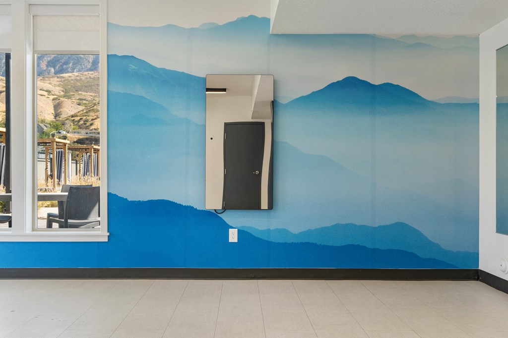 a blue wall with mountains painted on it and a door at The Flats at Riverwoods, Provo, UT