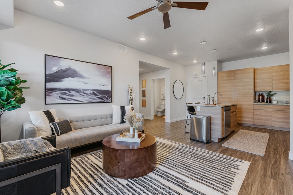 an open living room with a kitchen and a ceiling fan at The Flats at Riverwoods, Provo