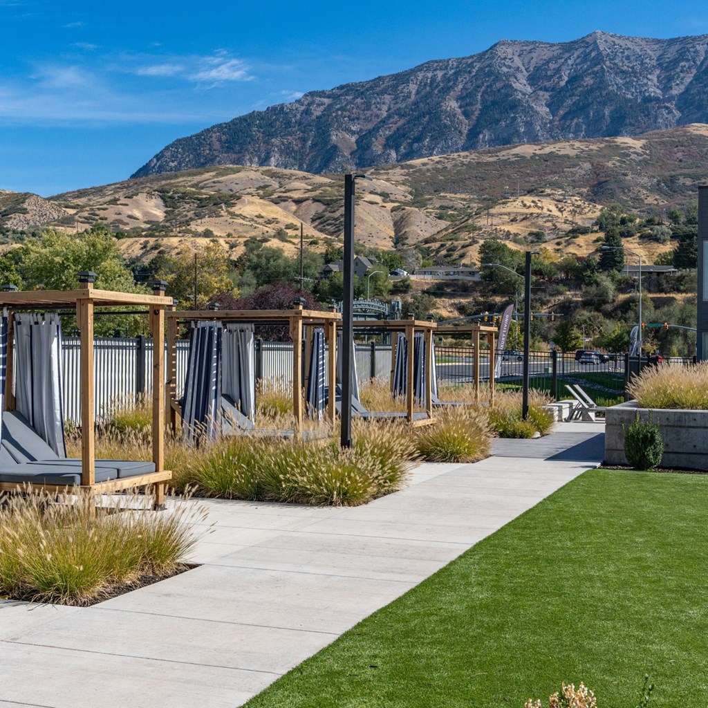 a view of the mountains from a park with benches and grass at The Flats at Riverwoods, Provo, UT, 84604