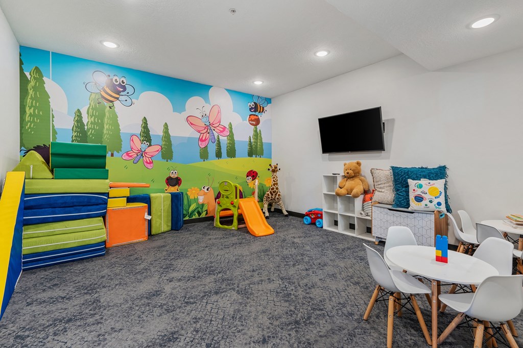 a play room with chairs and toys and a wall mural at The Flats at Riverwoods, Provo, UT