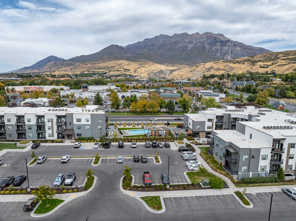 an aerial view of an apartment complex with a mountain in the background at The Flats at Riverwoods, Provo, UT