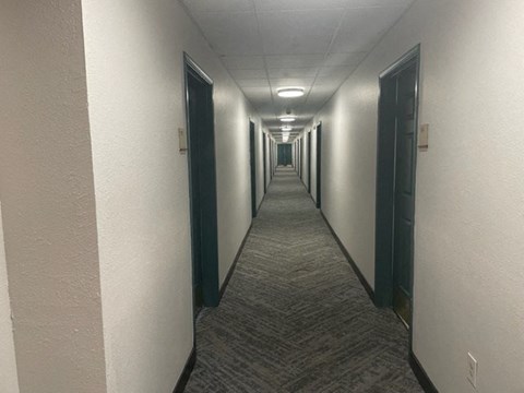 a long hallway with doors in a building