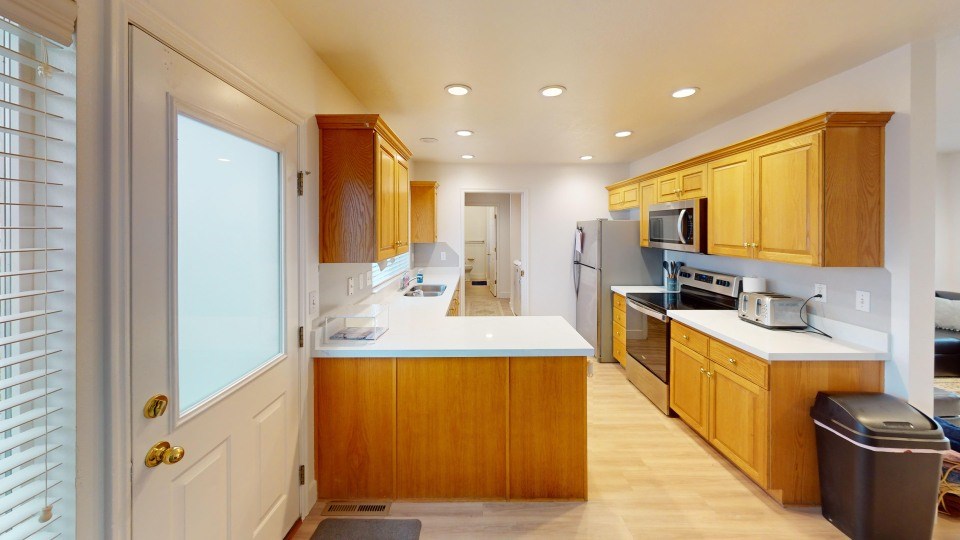 A kitchen with wooden cabinets and a white counter.