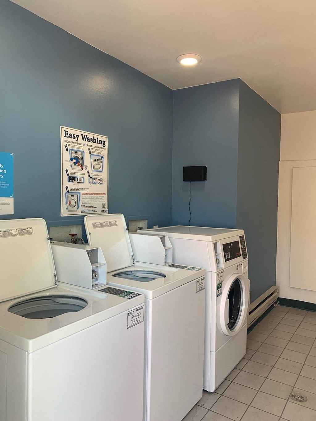 a laundry room with four washers and a dryer