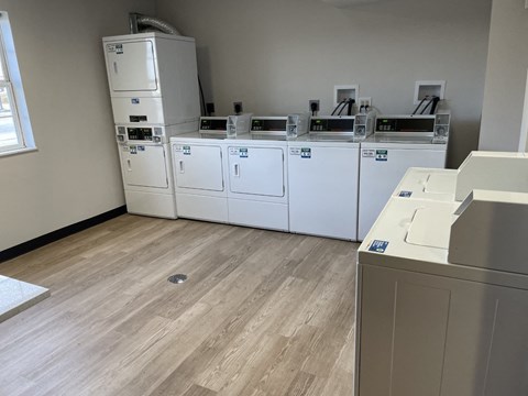 a row of white appliances in a room with wood floors
