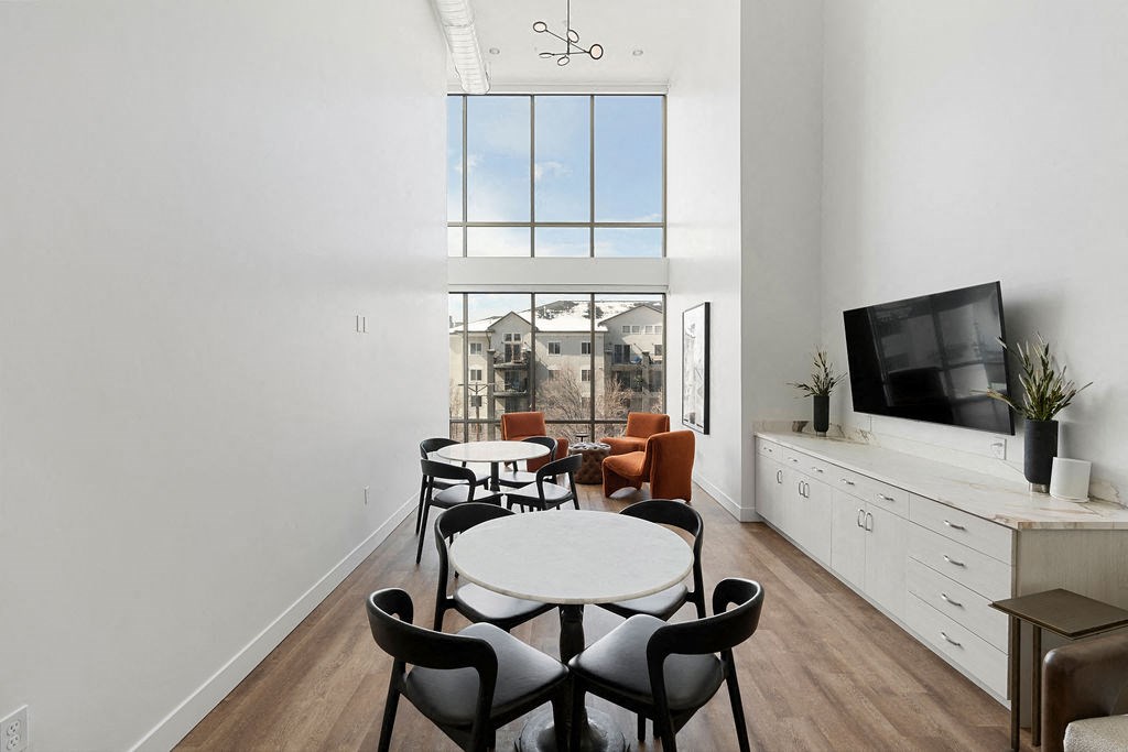 a living room with a table and chairs and a large window at The Revival, Salt Lake City, UT
