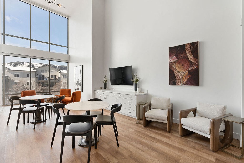 a living room with tables and chairs and a large window at The Revival, Utah, 84101