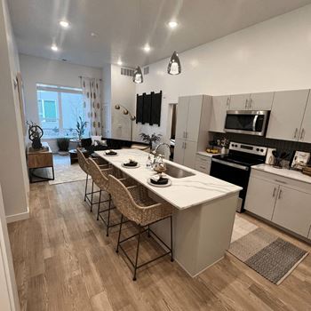an open kitchen and dining area with a marble counter top at SevenO2 Main Apartments, Utah, 84101