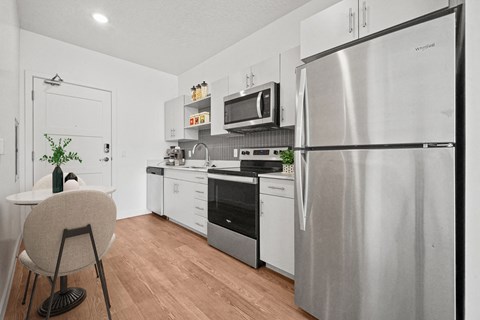 an apartment kitchen with stainless steel appliances and a table