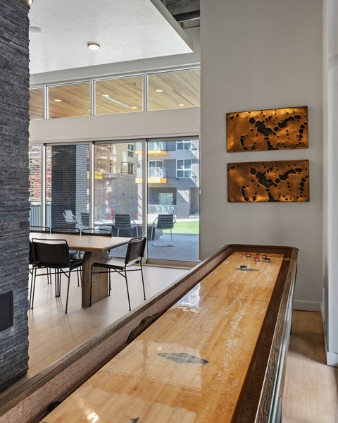 a long wooden table in a room with a large window at Paperbox Lofts, Salt Lake City, 84101