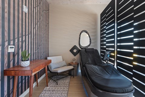a treatment room with a black chair and a mirror at Paperbox Lofts, Salt Lake City, UT