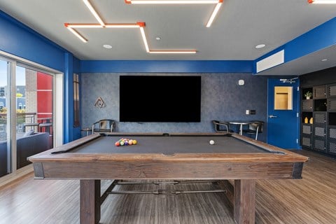 a pool table in a clubhouse with a tv on the wall at Paperbox Lofts, Salt Lake City, Utah