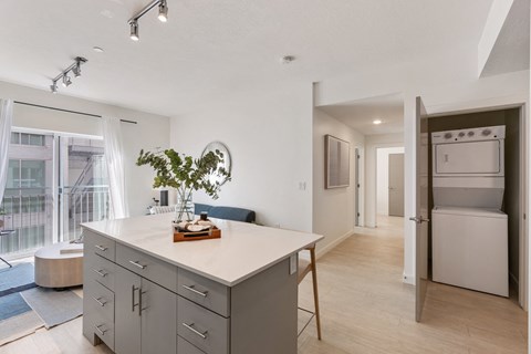 a kitchen with an island and a living room with a refrigerator at Paperbox Lofts, Salt Lake City, UT