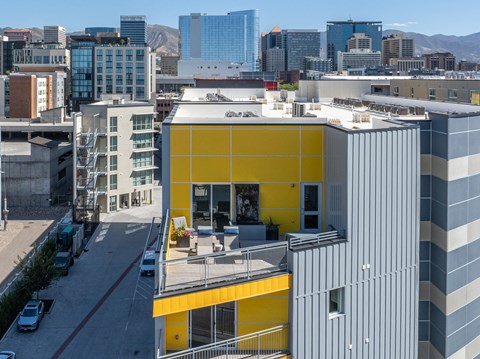 a building with a yellow facade and a city in the background at Paperbox Lofts, Salt Lake City, Utah