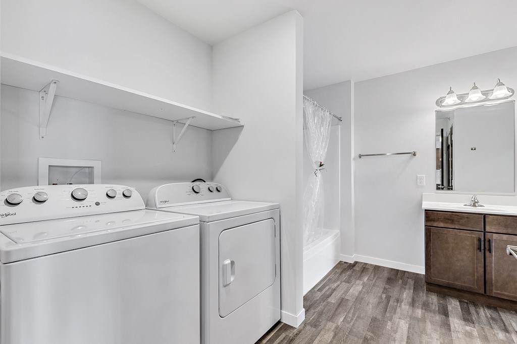a bathroom with a washer and dryer and a sink