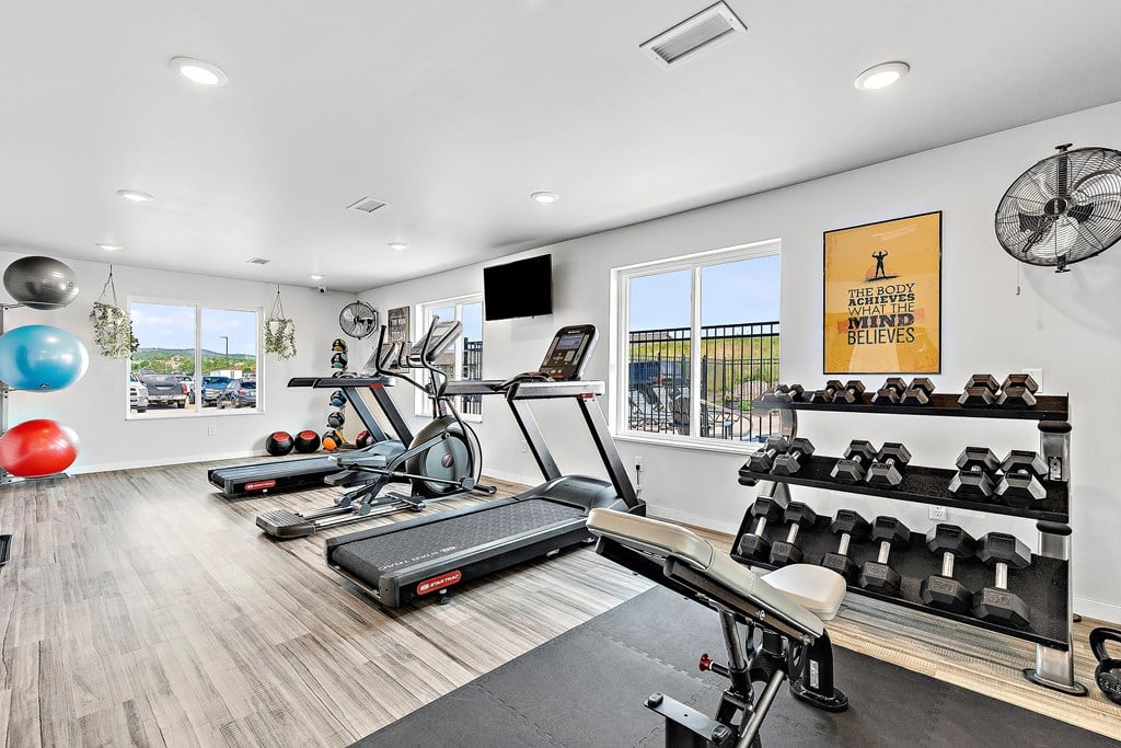 a workout room with treadmills and other exercise equipment