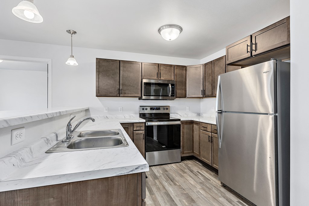 a kitchen with wooden cabinets and stainless steel appliances