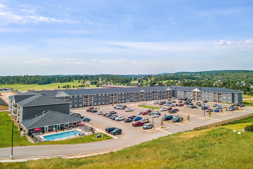 a large building with a pool and parking lot