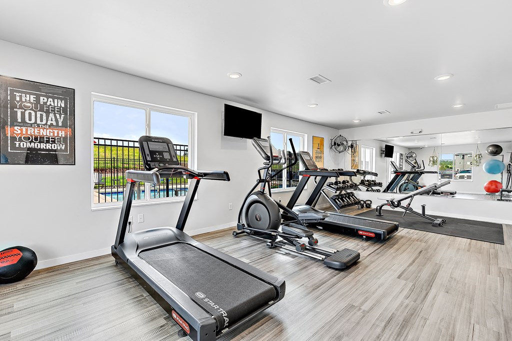 a workout room with treadmills and other exercise equipment