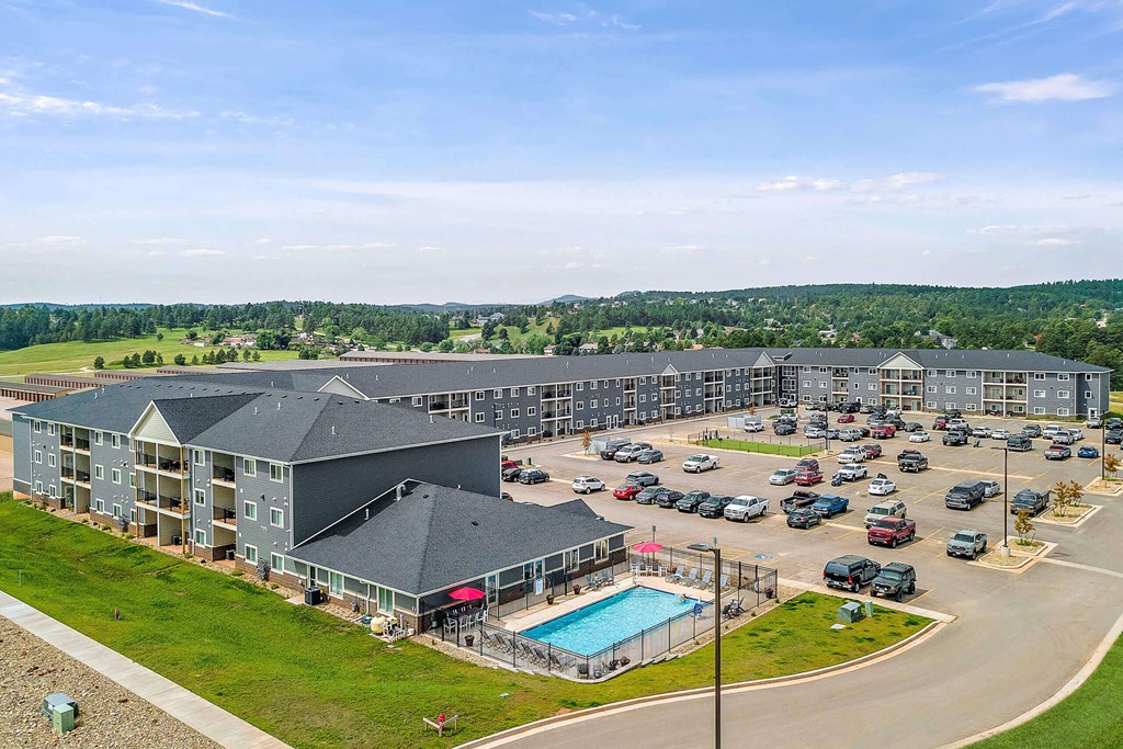 a large apartment complex with a swimming pool and parking lotv