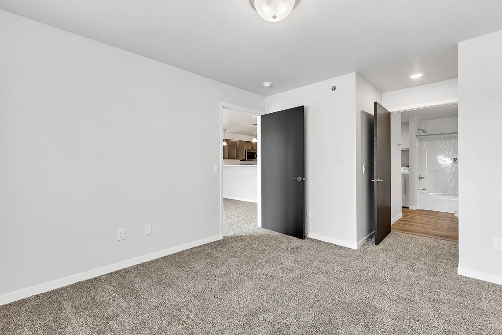a bedroom with grey carpet and white walls at Red Rock Apartments, Rapid City, SD