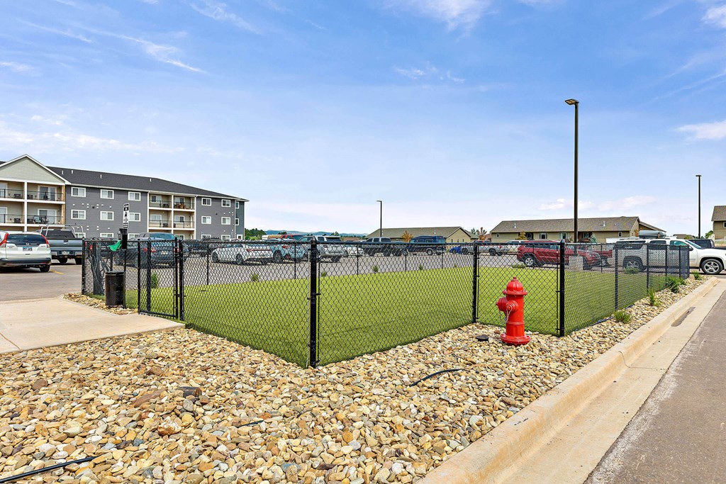 a view of a dog park with a red fire hydrant in front at Red Rock Apartments, Rapid City, 57702