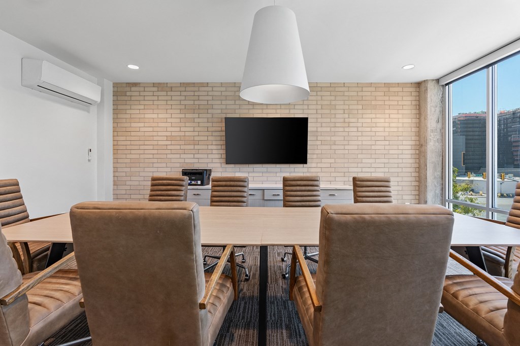 a conference room with a table and chairs and a tv on the wall at The Revival, Salt Lake City, 84101