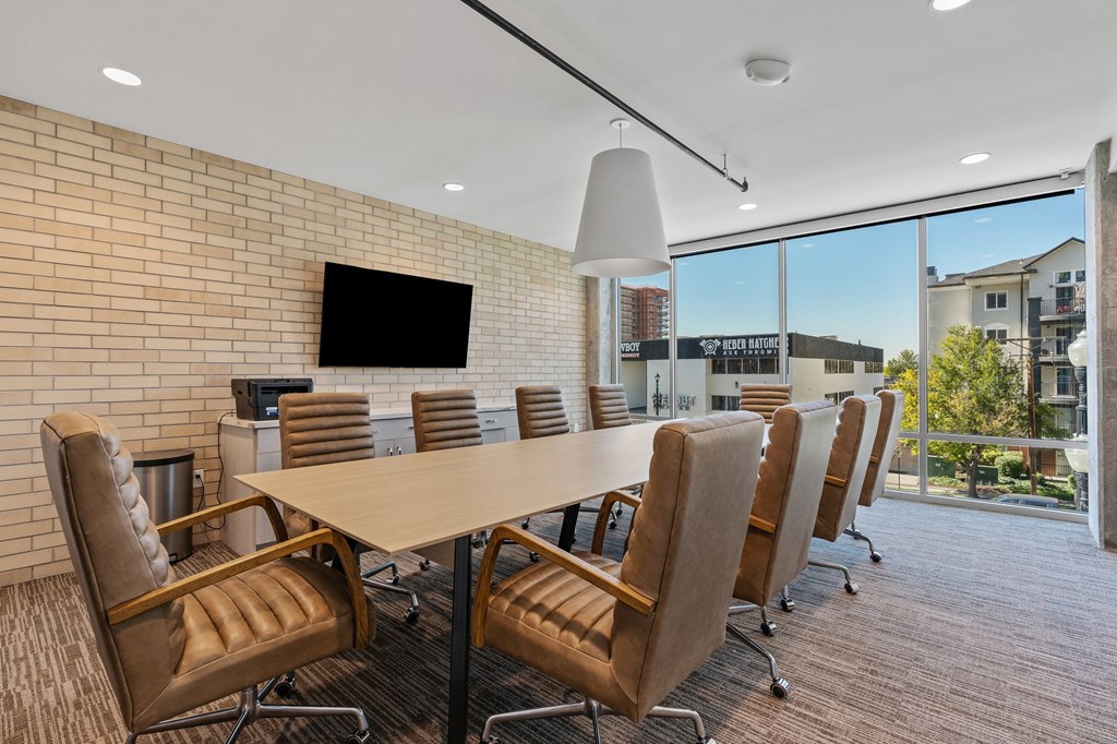 a conference room with a long table and chairs and a large window at The Revival, Salt Lake City