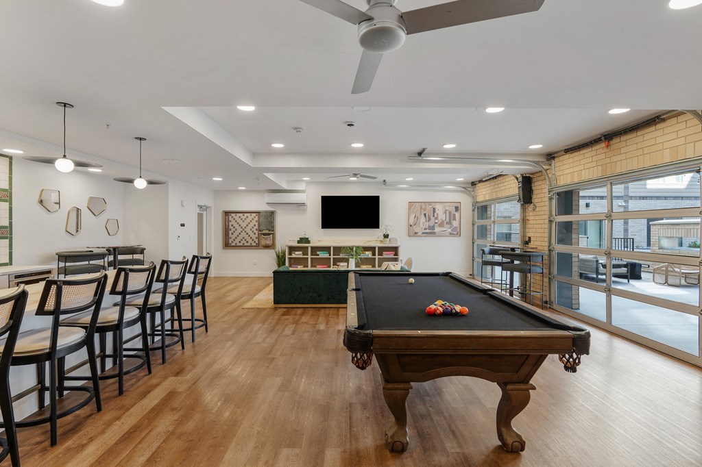a game room with a pool table and a bar with chairs at The Revival, Salt Lake City