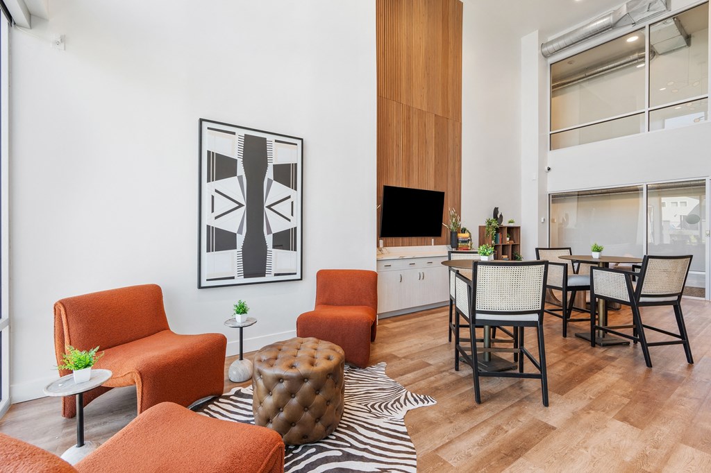 a living room with orange furniture and a dining room with a table and chairs at The Revival, Salt Lake City, UT, 84101
