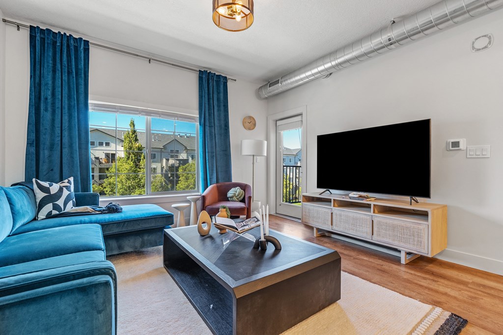 a living room with blue couches and a tv at The Revival, Salt Lake City