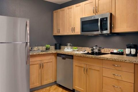 A kitchen with wooden cabinets and a granite countertop.